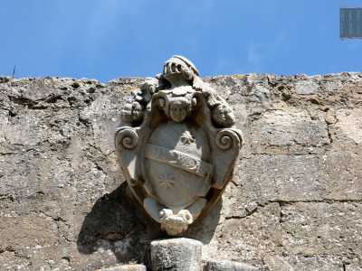 L'ingresso � sovrastato dallo uno stemma a forma di mandorla racchiuso lateralmente da due volute gemelle e nella parte superiore da due putti. E� l�emblema dei Lattanzi, proprietari di questo immobile: la masseria Arbinetto